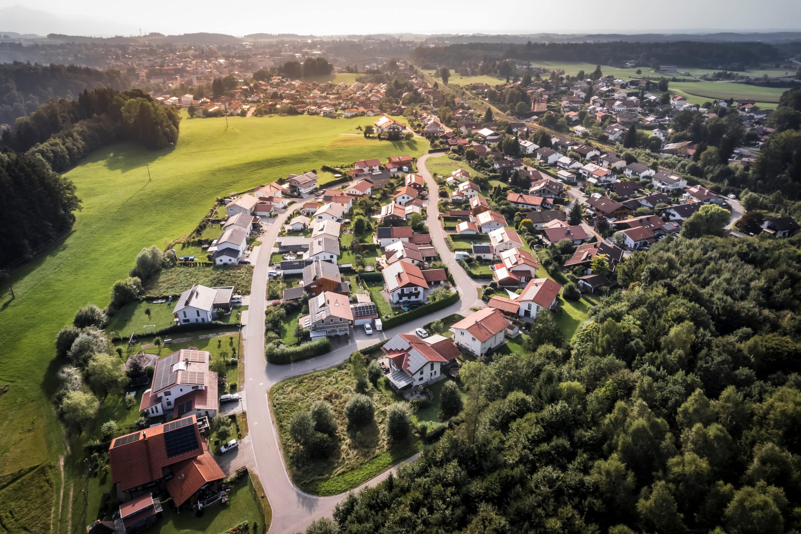 Luftaufnahme eines Wohngebiets mit Einfamilienhäusern und grünen Flächen, ideal für schnelle Internetverbindungen von Unsere Grüne Glasfaser.