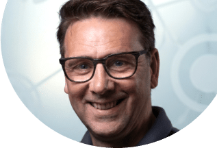 Lächelnder Mann mit Brille, der die Vorteile von Unsere Grüne Glasfaser präsentiert und für digitale Vernetzung steht.